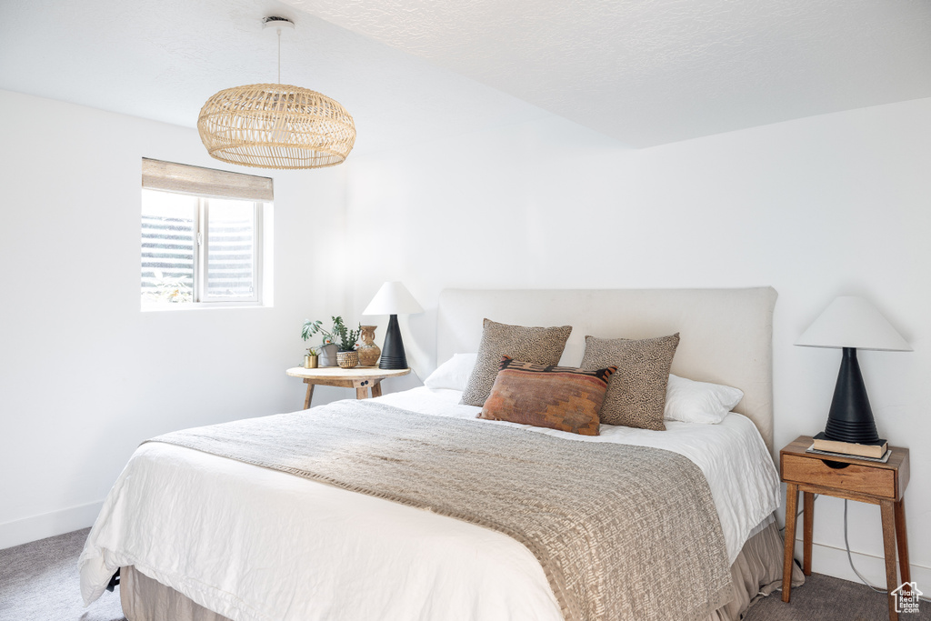 Bedroom with carpet floors, baseboards, and a chandelier
