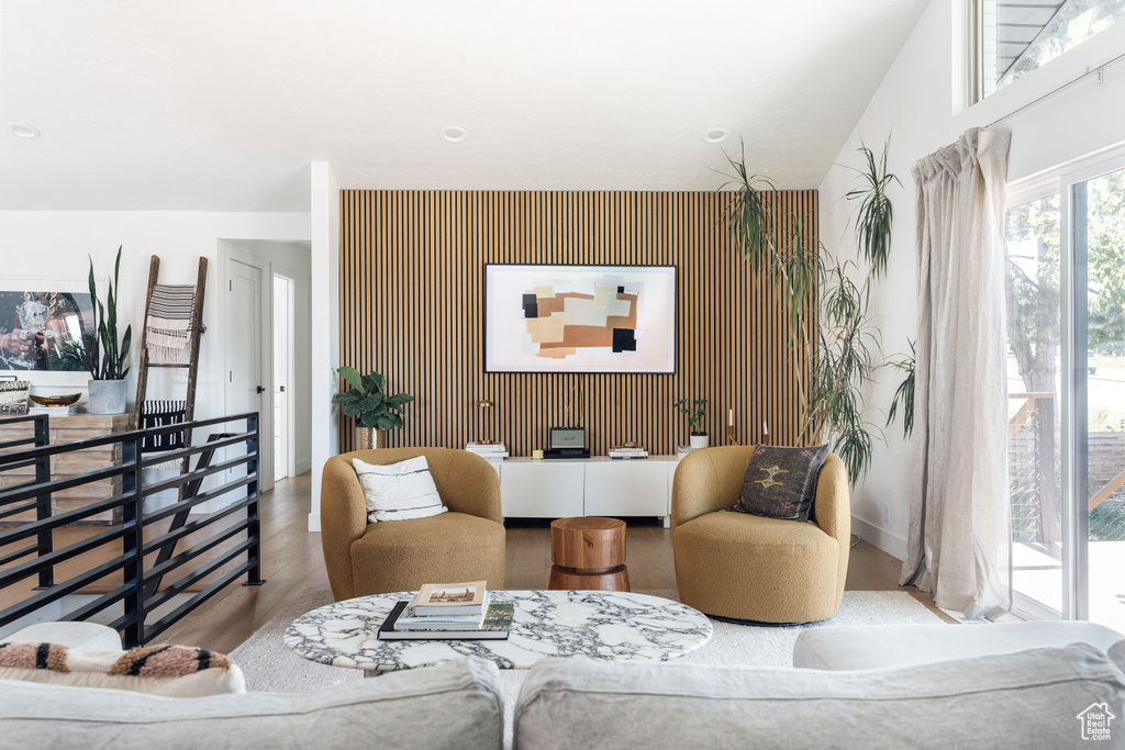 Living area featuring an accent wall and wood finished floors