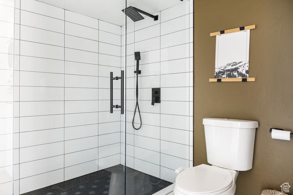 Full bath featuring toilet and a stall shower
