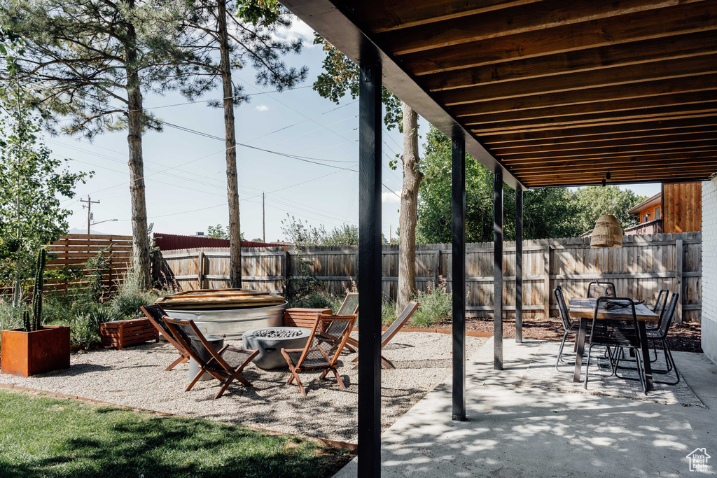 Fenced backyard with a patio area, a fire pit, and outdoor dining space