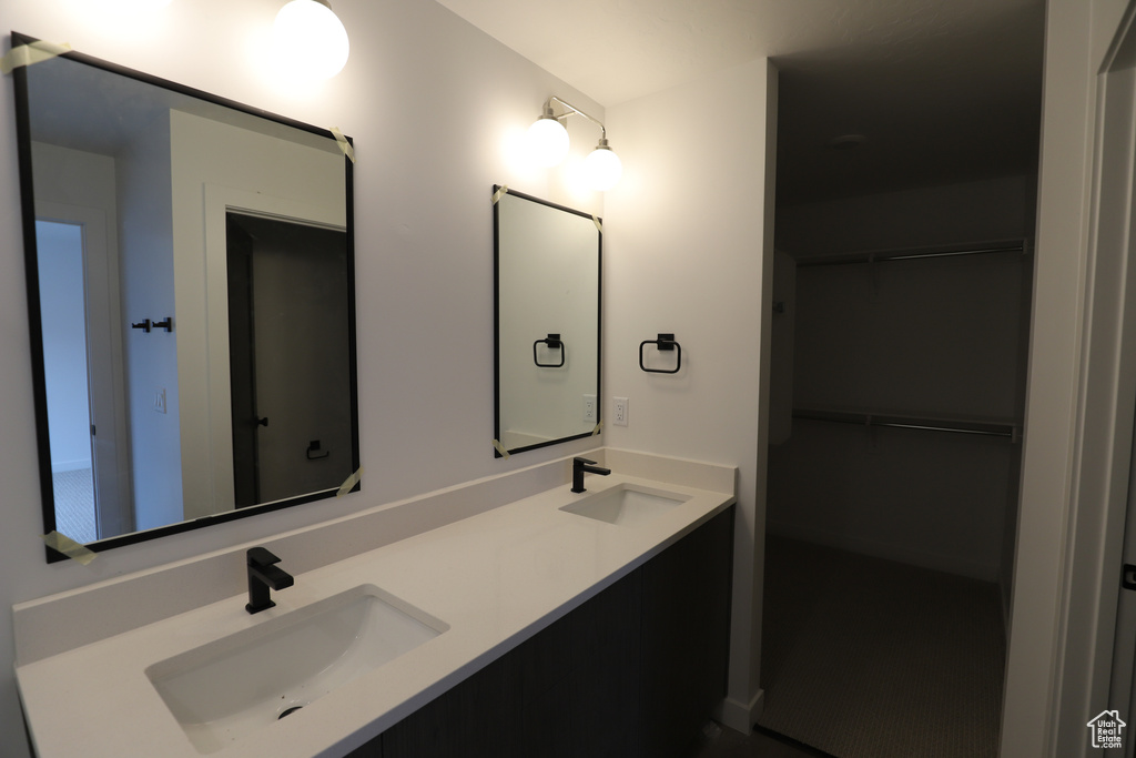 Full bathroom with double vanity and a spacious closet