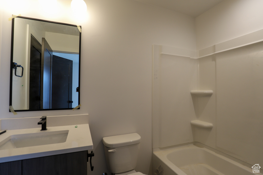 Bathroom featuring vanity, toilet, and  shower combination