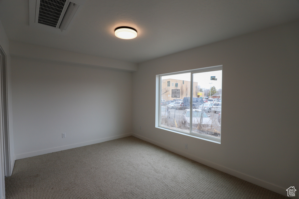 Spare room with carpet and baseboards