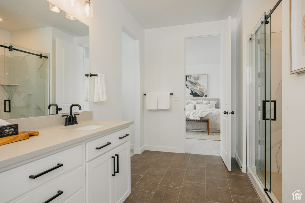 Ensuite bathroom with vanity, a marble finish shower, and baseboards