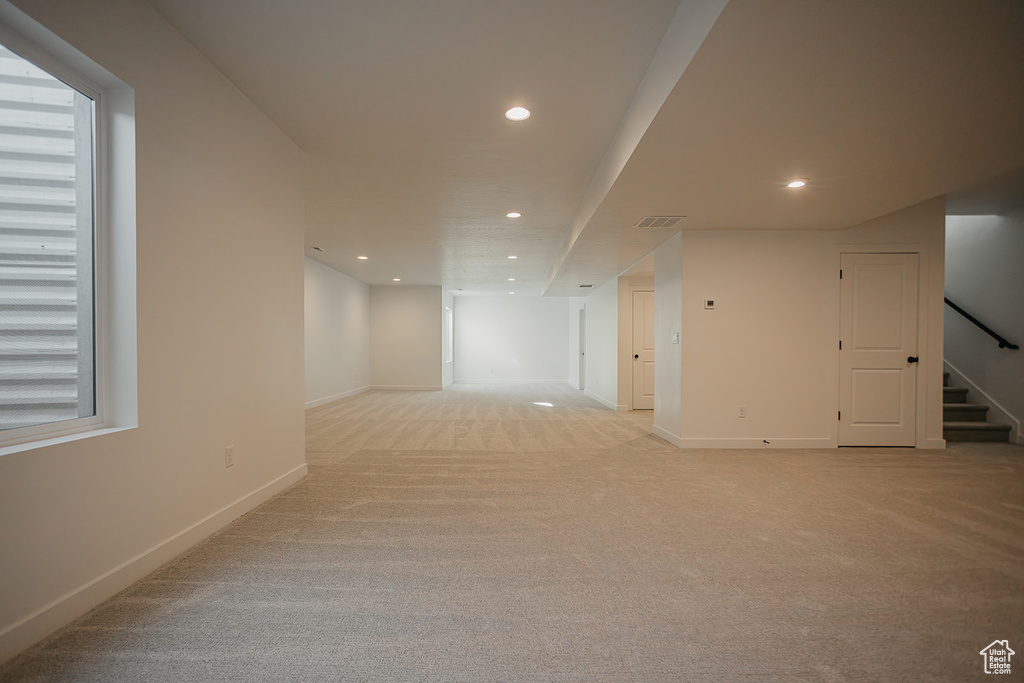 Spare room with recessed lighting, stairway, light carpet, and baseboards
