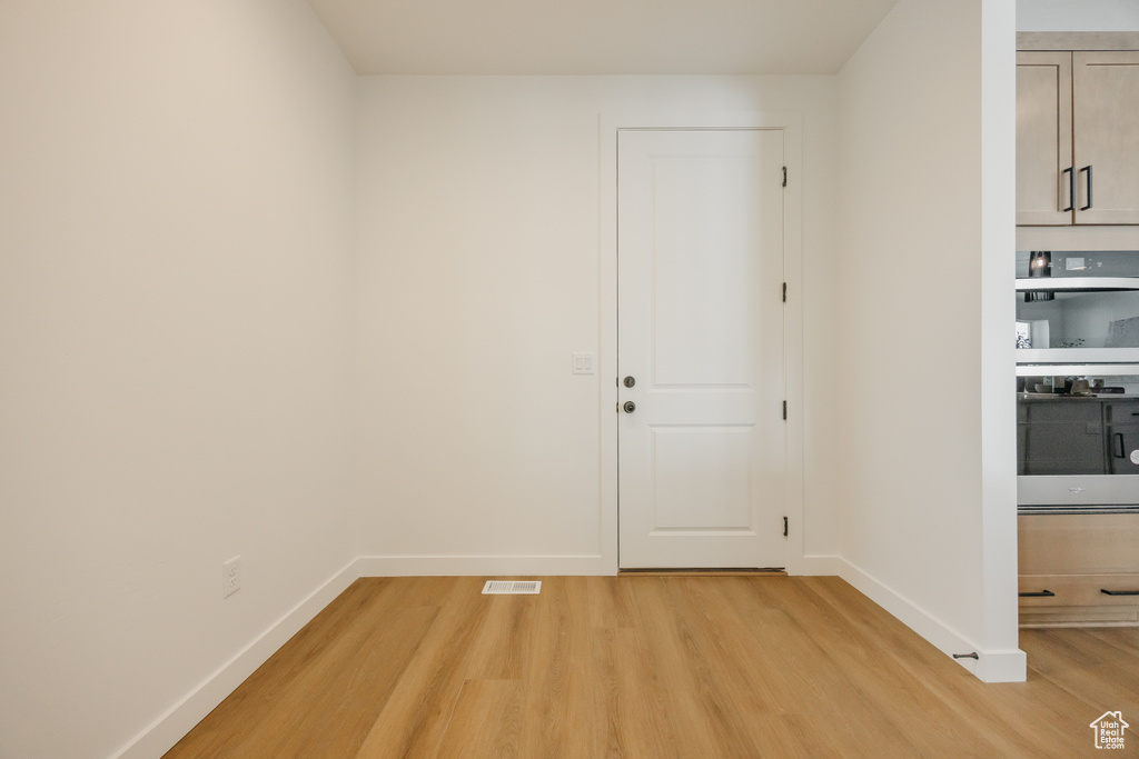 Unfurnished room with light wood-style floors and baseboards