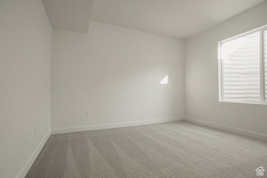 Carpeted empty room featuring baseboards