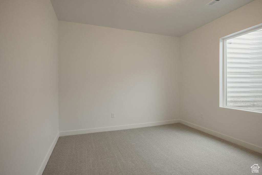 Unfurnished room with light colored carpet and baseboards
