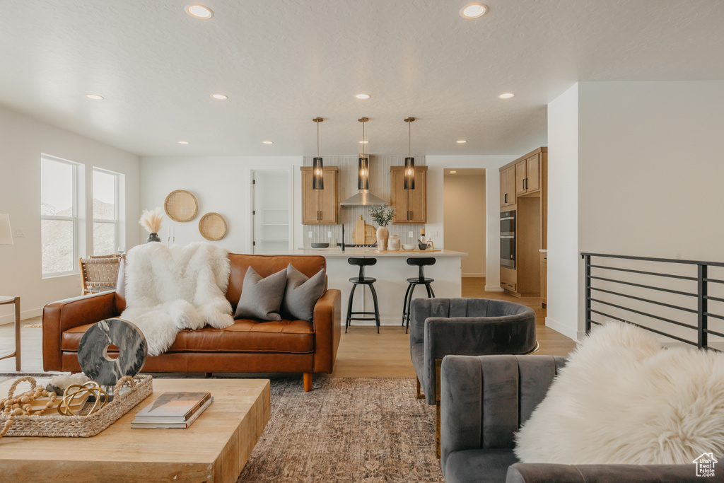 Living room featuring recessed lighting, light wood-style flooring, and baseboards