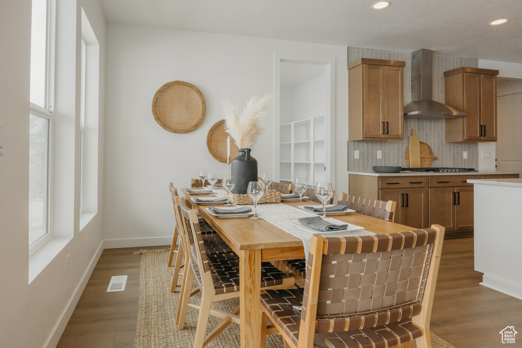 Dining room with healthy amount of natural light, baseboards, light wood-style floors, and recessed lighting