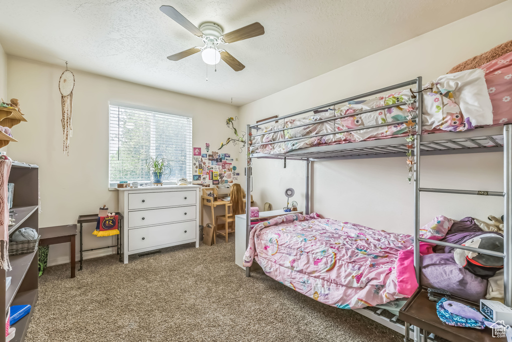 Carpeted bedroom featuring a ceiling fan