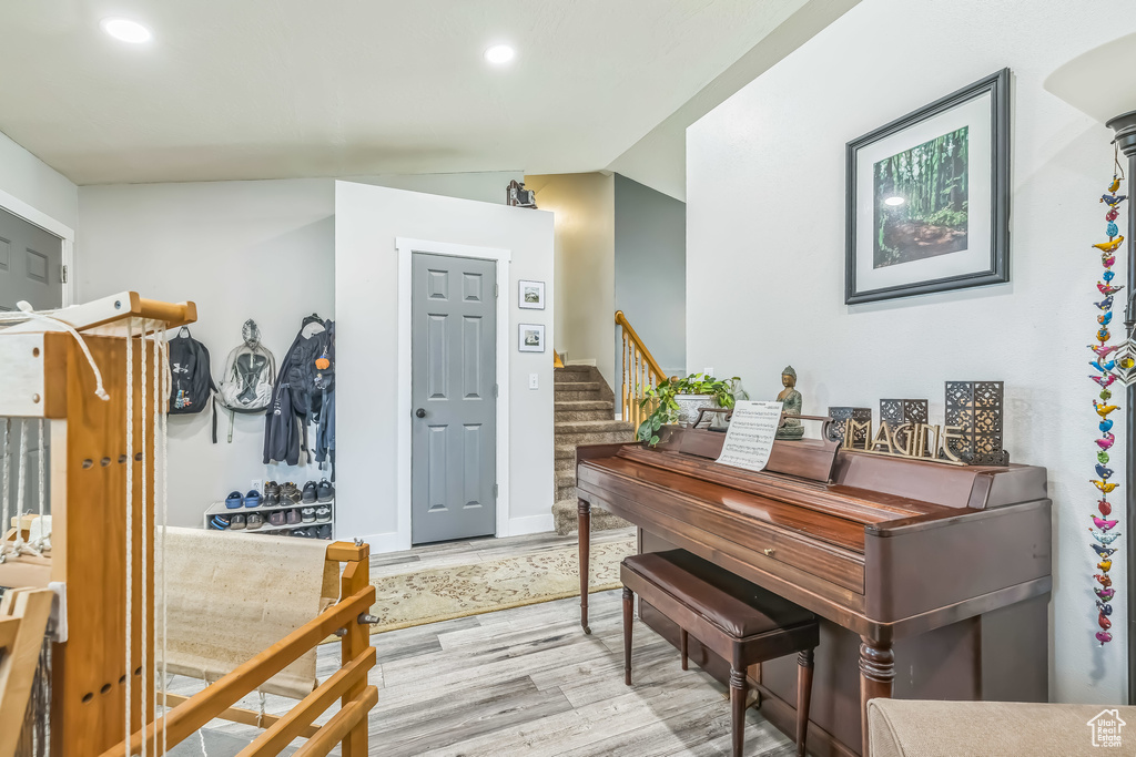 Entrance foyer featuring wood finished floors, stairs, recessed lighting, baseboards, and lofted ceiling