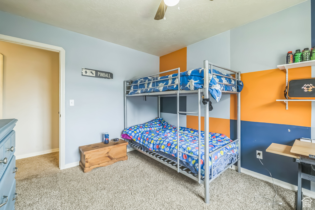 Carpeted bedroom featuring baseboards and ceiling fan