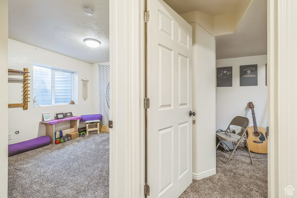 Corridor featuring carpet floors and baseboards
