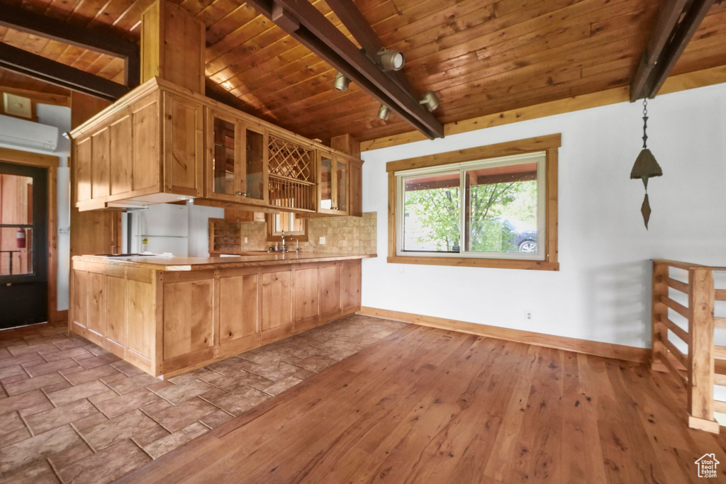 Kitchen with baseboards, wooden ceiling, a wall mounted AC, glass insert cabinets, and a peninsula