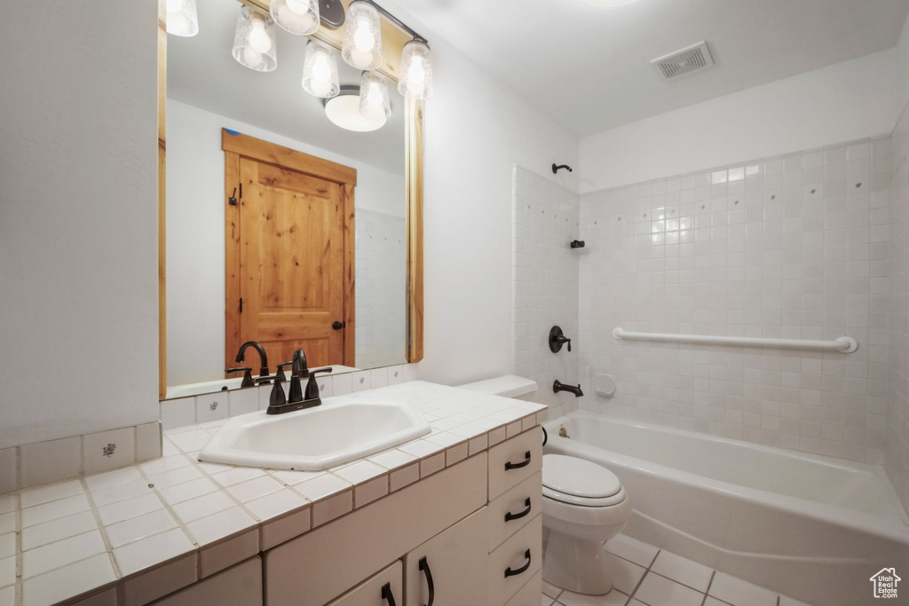 Bathroom featuring toilet, vanity, bathing tub / shower combination, and tile patterned flooring