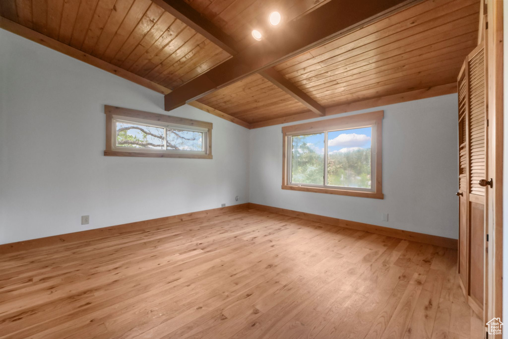 Unfurnished bedroom with light wood finished floors, wooden ceiling, and baseboards