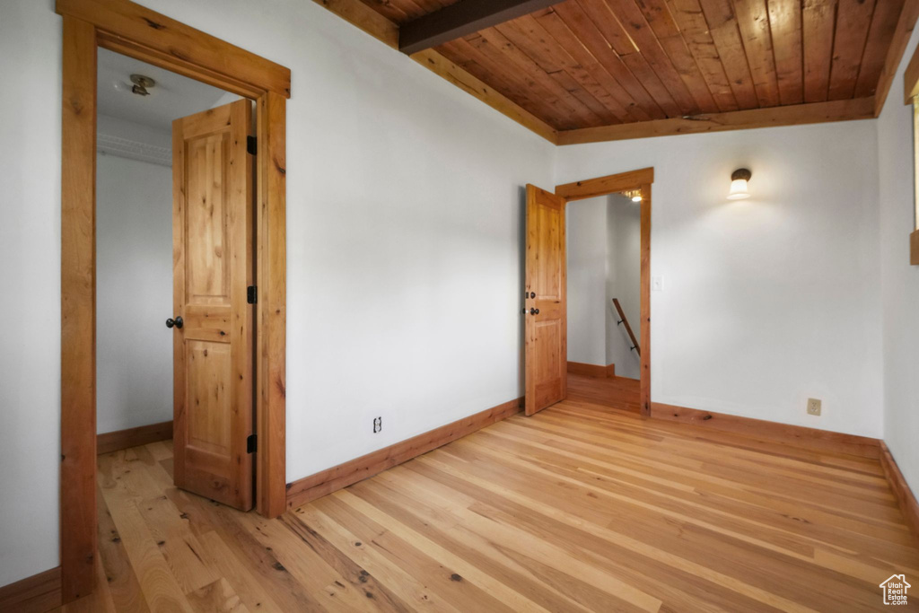 Spare room featuring wooden ceiling, light wood-style floors, and baseboards