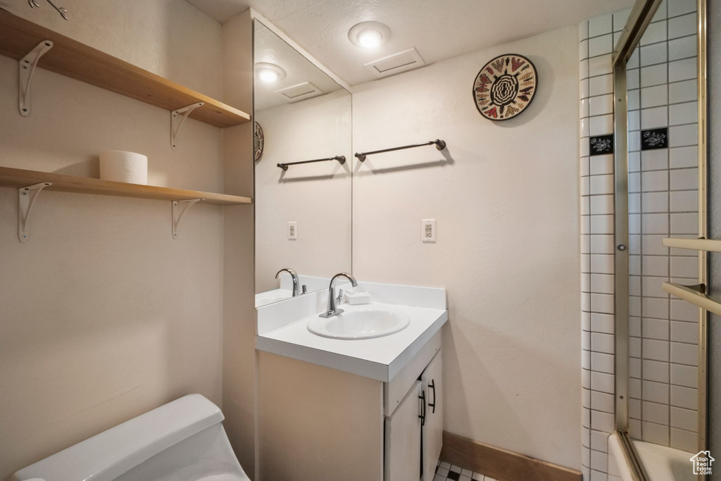 Full bathroom featuring toilet, vanity, shower / bath combination, and baseboards