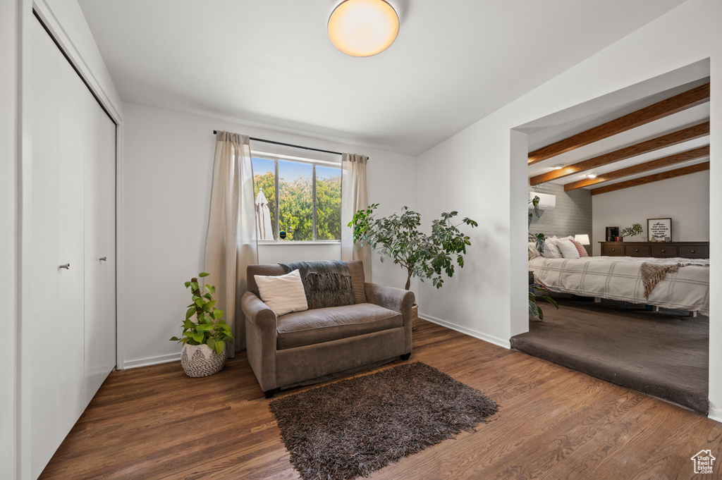 Sitting room featuring wood finished floors, baseboards, and beam ceiling