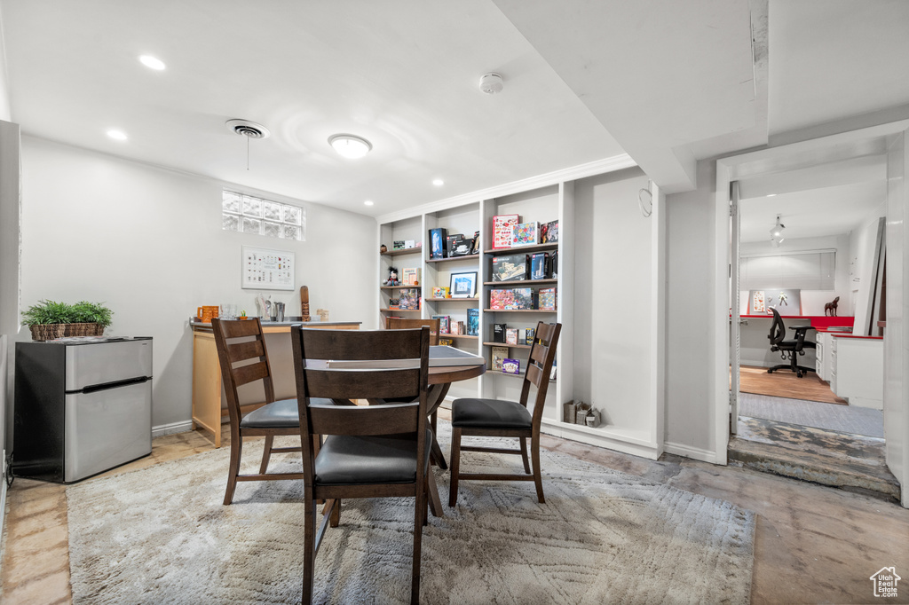Dining room with wet bar, recessed lighting, concrete floors, and baseboards