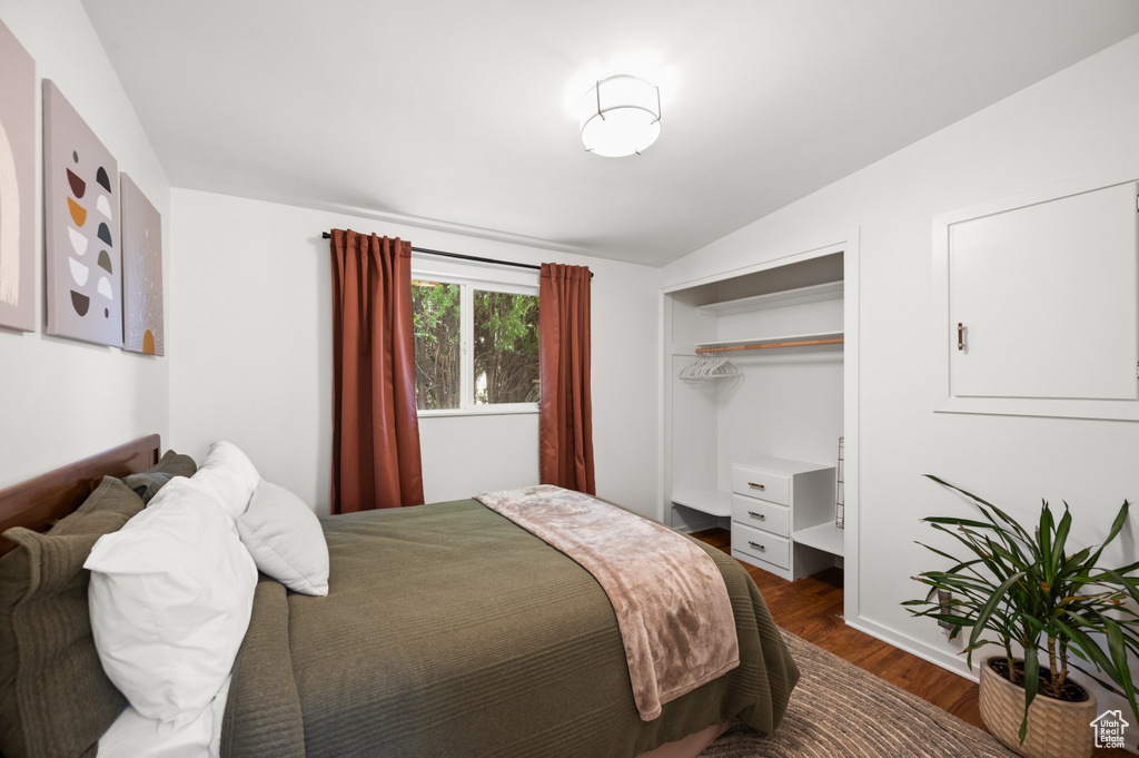 Bedroom featuring vaulted ceiling, dark wood finished floors, and a closet
