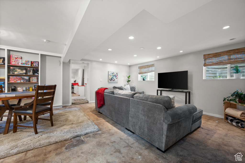 Living room with recessed lighting, baseboards, and concrete floors