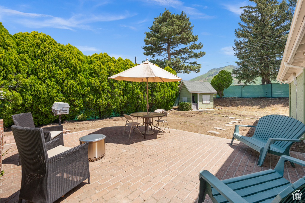 View of patio with an outdoor structure, outdoor dining area, and a mountain view