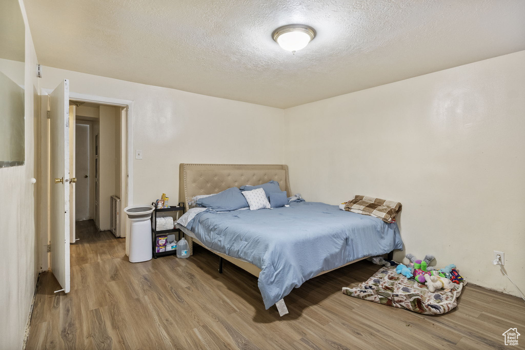 Bedroom featuring wood finished floors and a textured ceiling