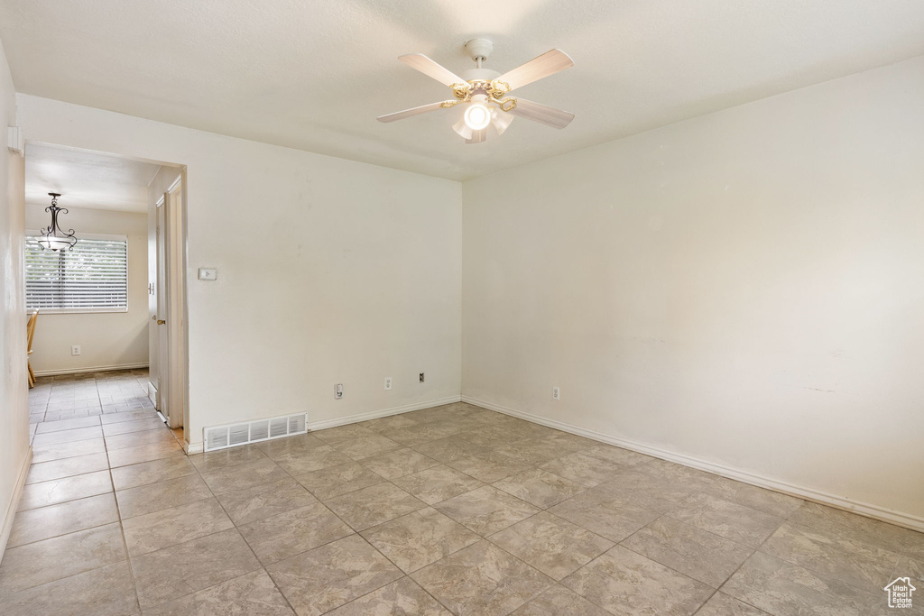 Unfurnished room with ceiling fan, baseboards, and light tile patterned floors