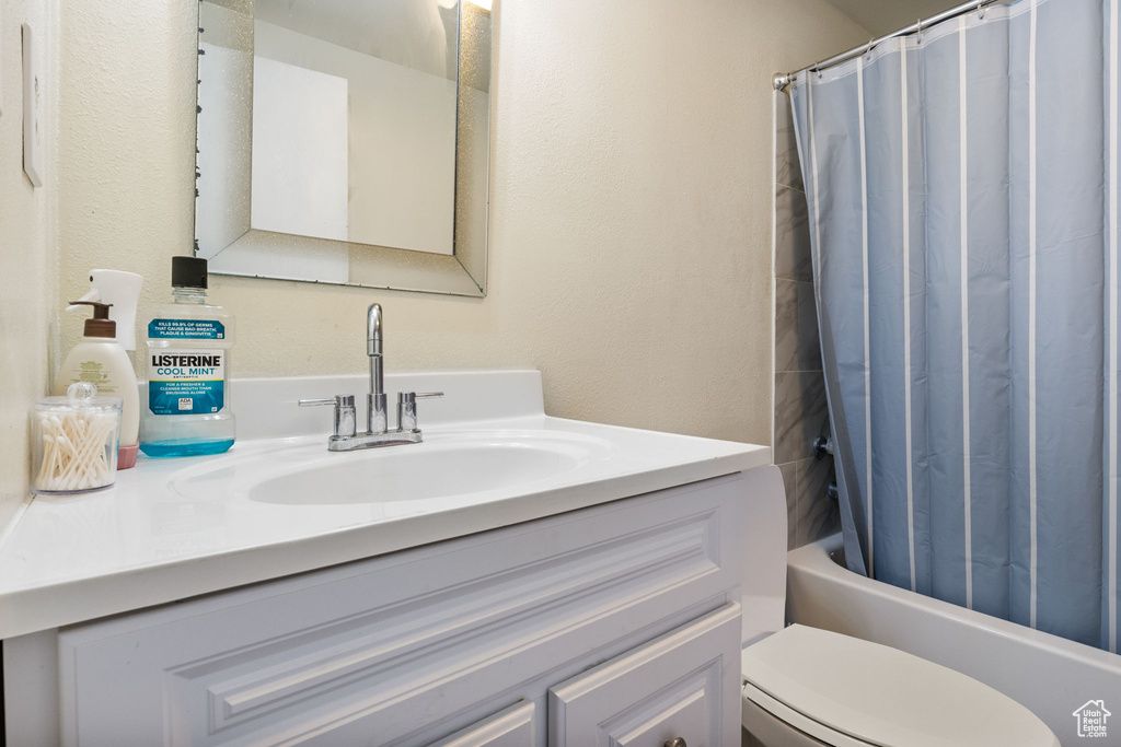 Bathroom featuring vanity, toilet, and shower / bath combo