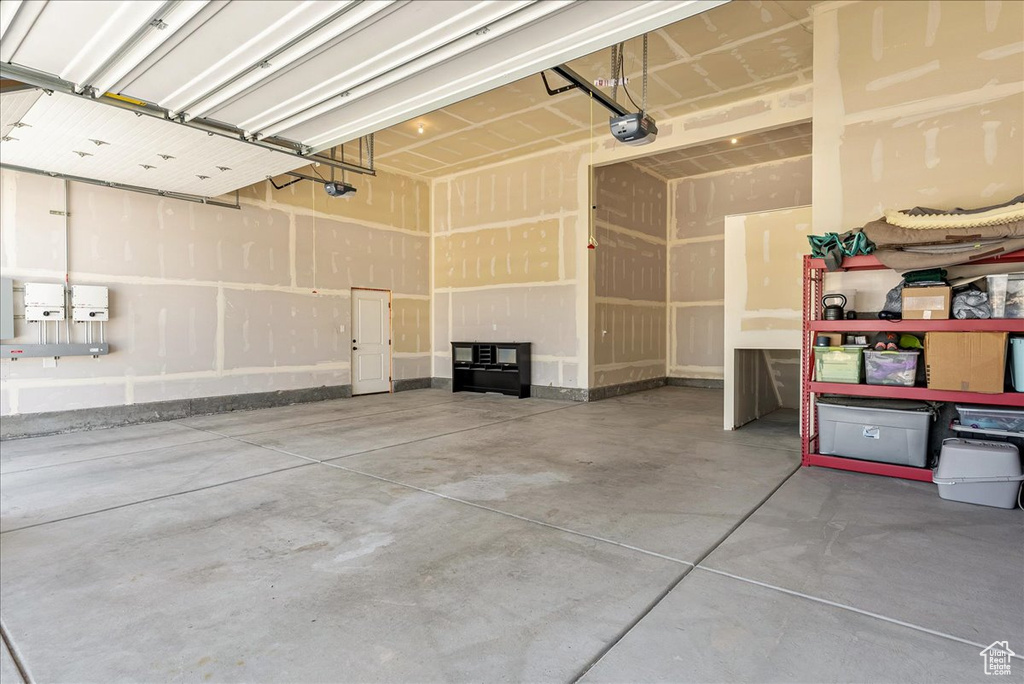 Garage with a garage door opener and baseboards