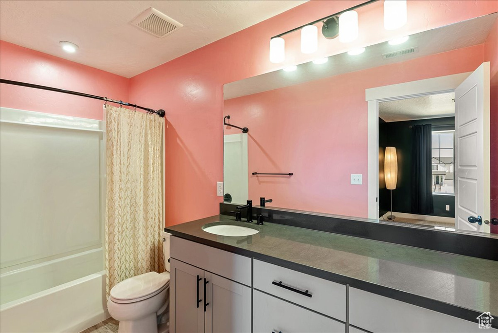 Full bath with toilet, shower / bath combo, and vanity