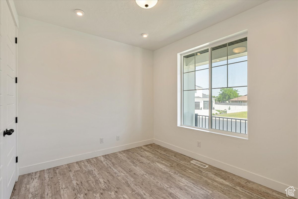 Spare room featuring wood finished floors, baseboards, and recessed lighting