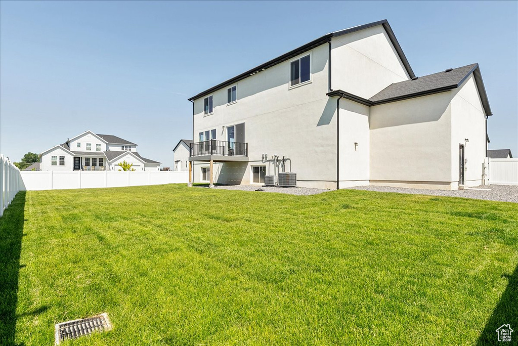 Rear view of house with stucco siding and central air condition unit