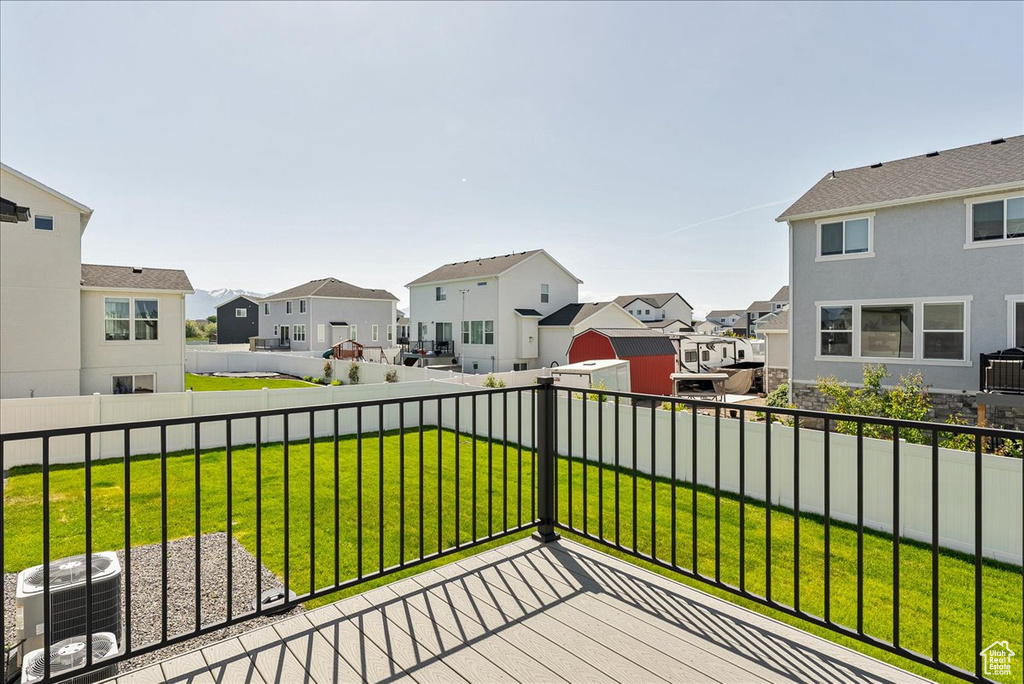 Wooden deck featuring a residential view and central AC unit