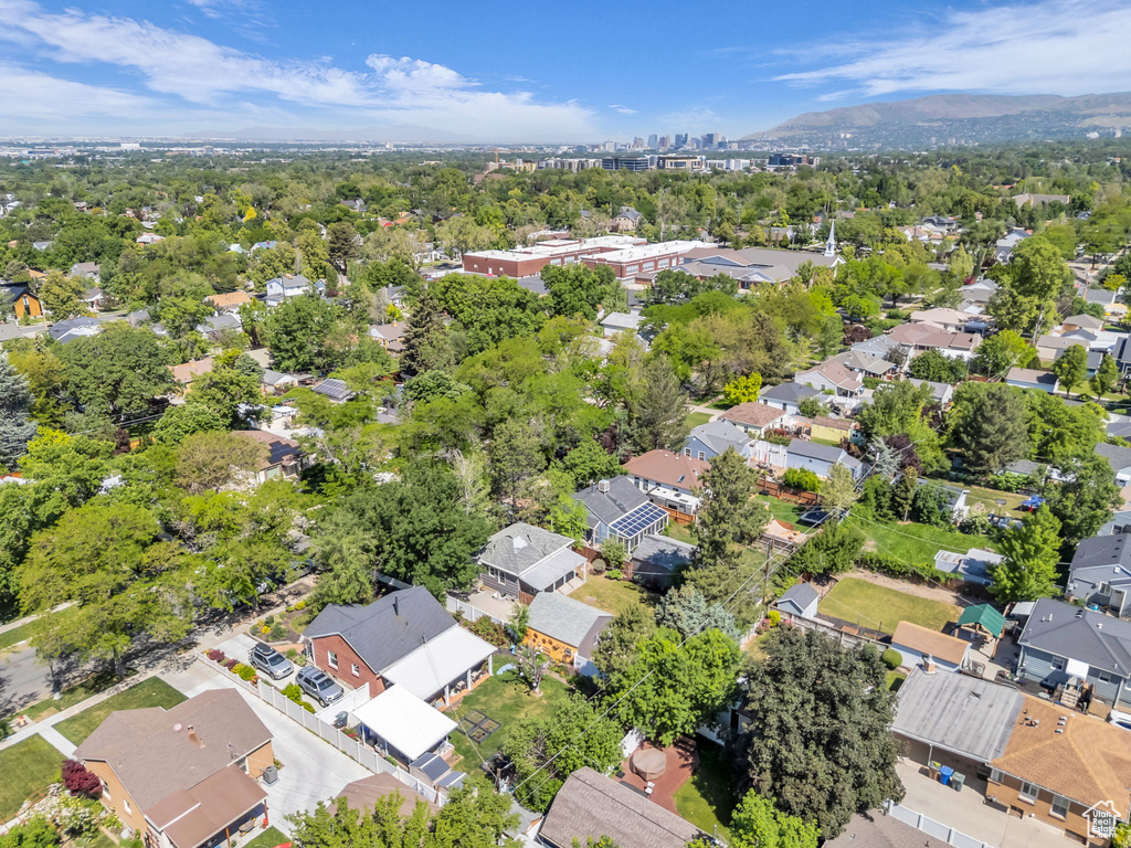 Aerial view of property and surrounding area with nearby suburban area and a mountain backdrop