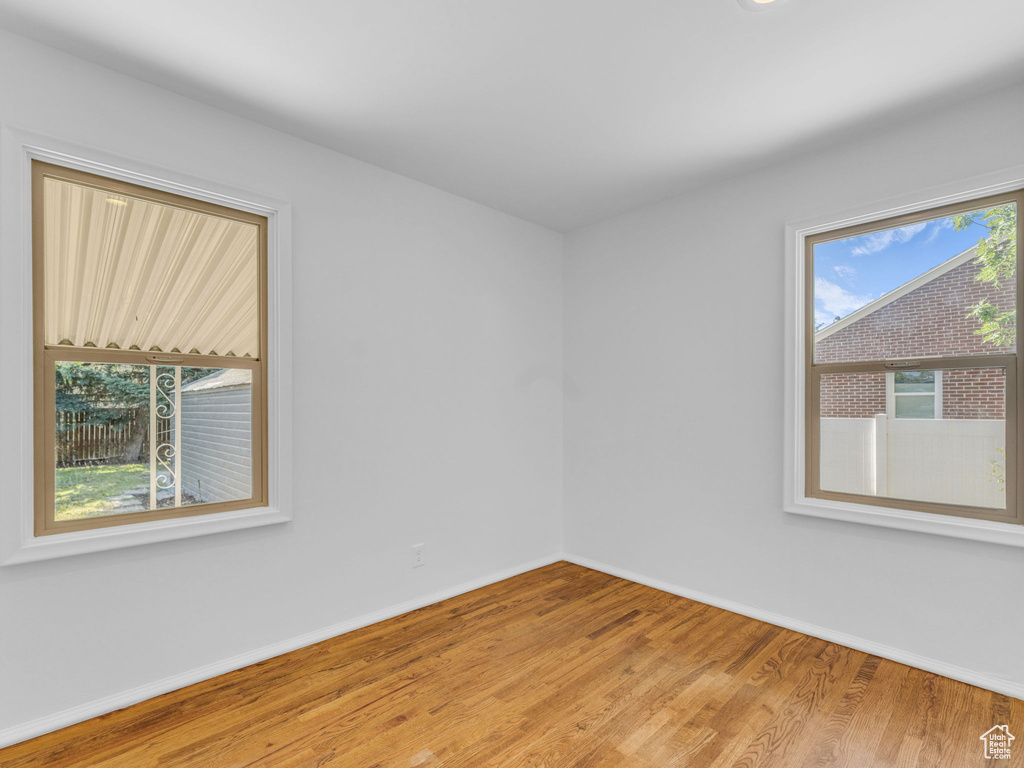 Spare room featuring baseboards and wood finished floors