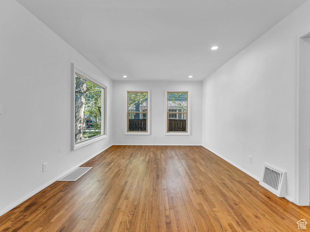 Spare room featuring hardwood / wood-style flooring, recessed lighting, and baseboards