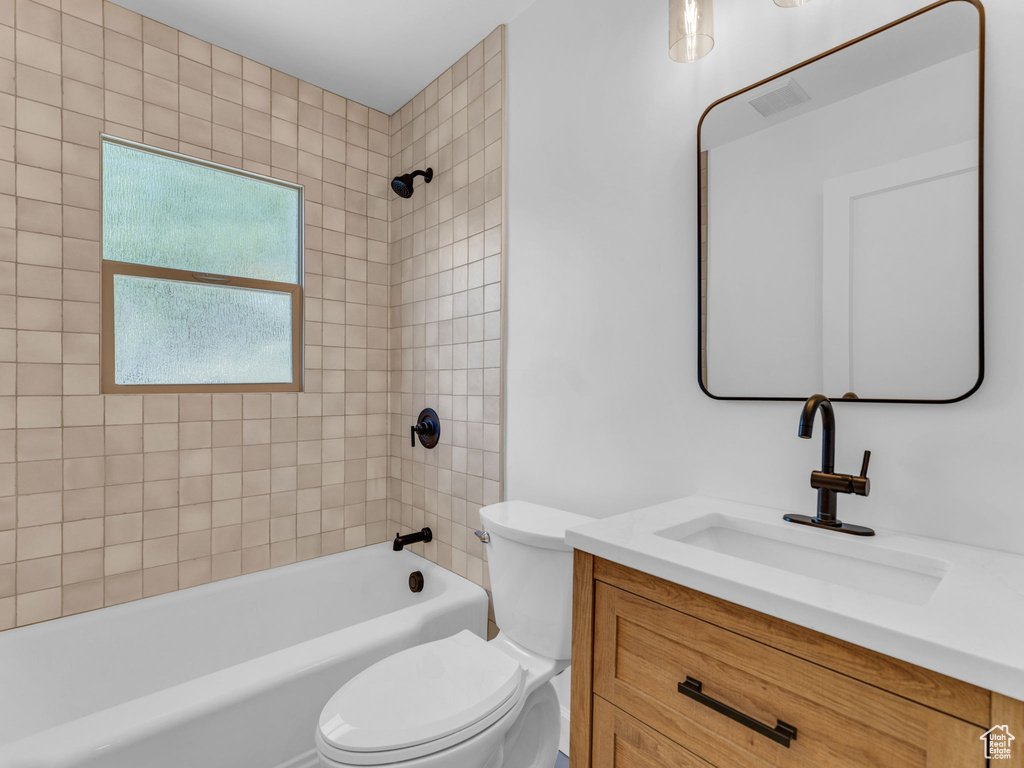 Bathroom with vanity, toilet, and shower / bathtub combination