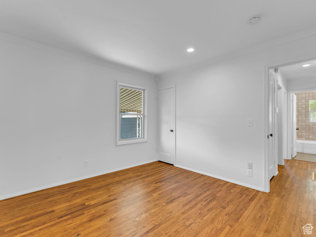 Spare room with ornamental molding, light wood finished floors, a smoke detector, recessed lighting, and baseboards