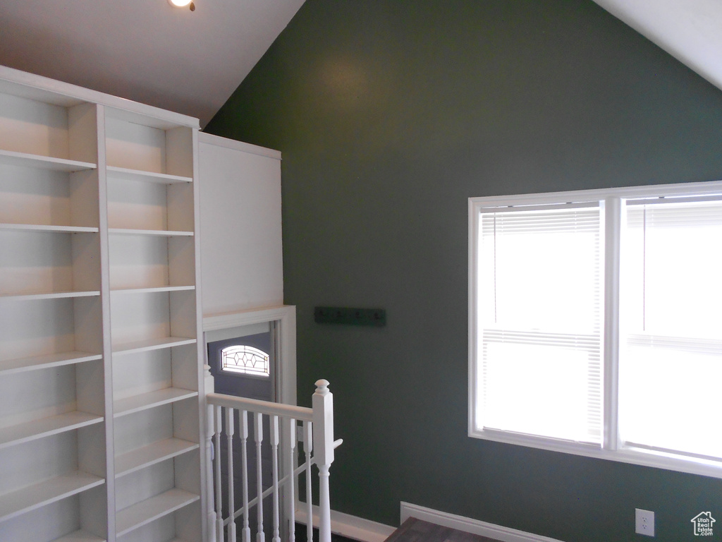 Stairs featuring lofted ceiling and baseboards