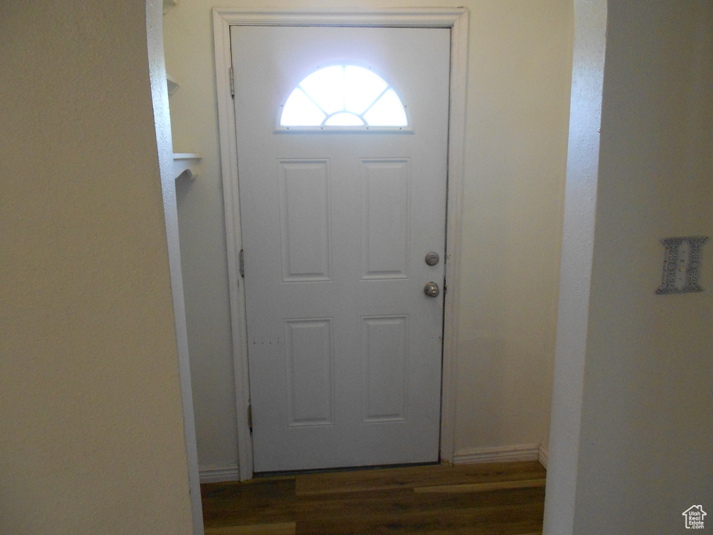 Foyer entrance featuring dark wood-style floors and baseboards