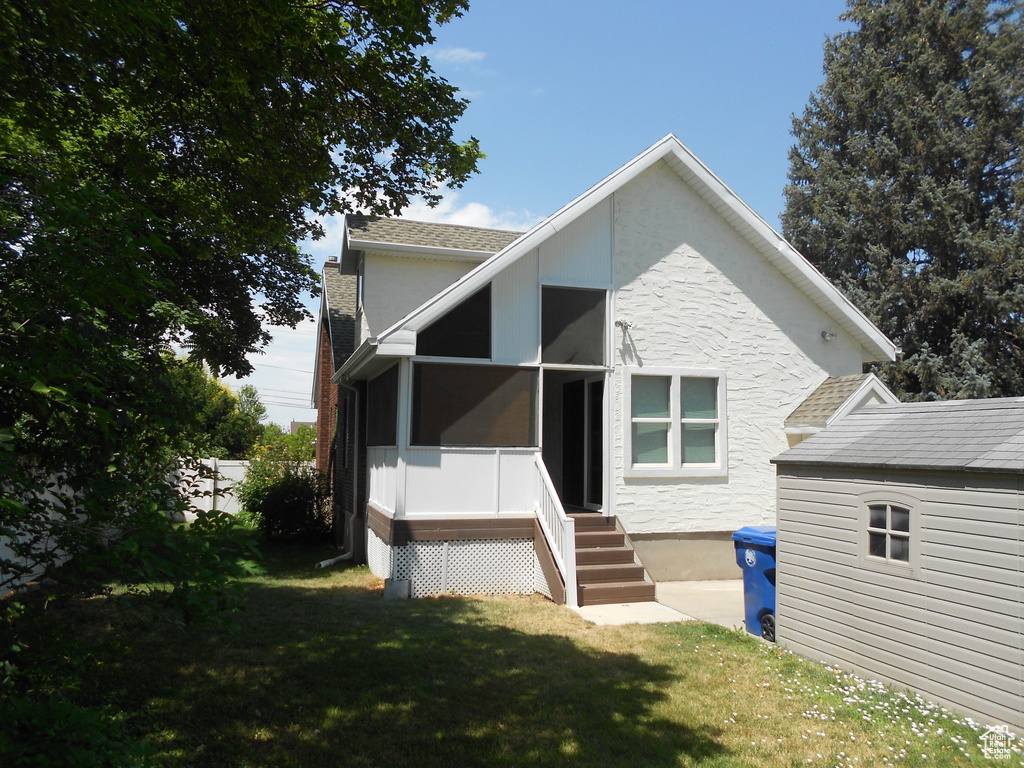 Back of property featuring a yard and stucco siding