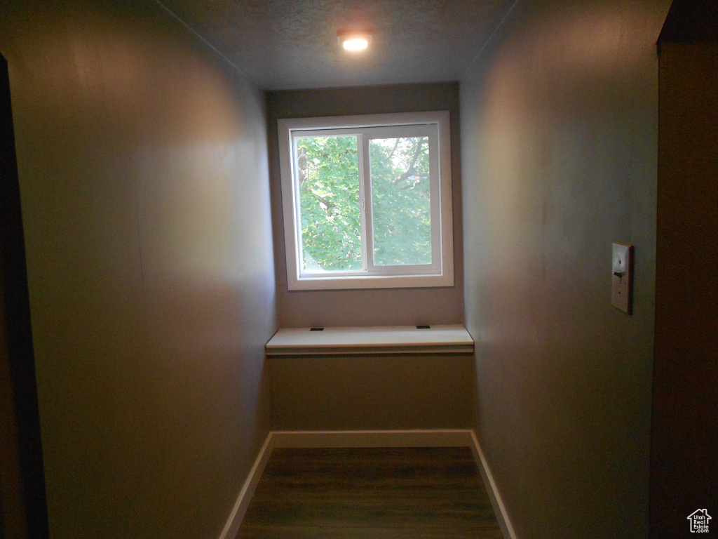 Corridor with baseboards and dark wood-type flooring