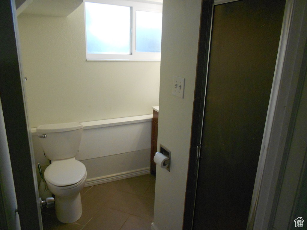 Bathroom with vanity, toilet, tile patterned floors, a shower with shower door, and baseboards
