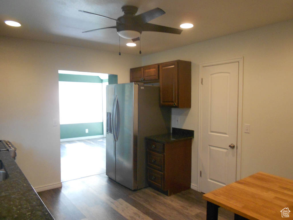 Kitchen featuring stainless steel refrigerator with ice dispenser, a ceiling fan, recessed lighting, dark wood-style flooring, and baseboards