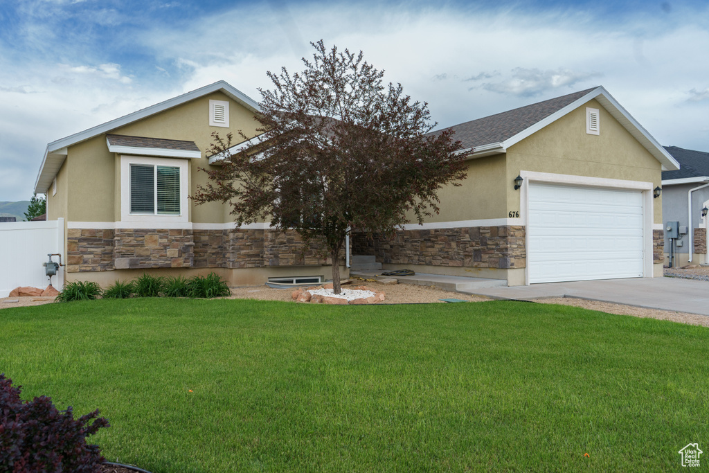 View of front of house with stone siding, stucco siding, and a front yard