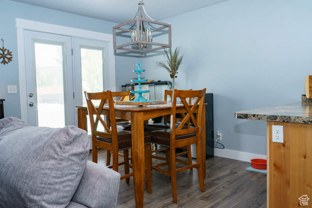Dining area featuring a chandelier, dark wood-type flooring, and baseboards