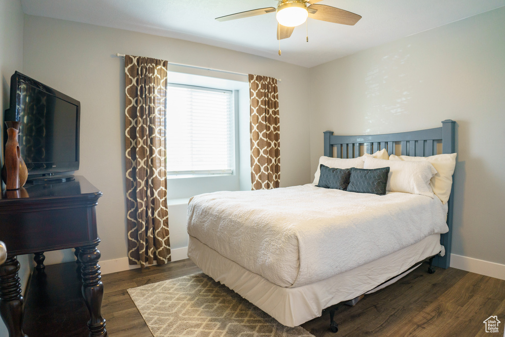 Bedroom with wood finished floors, baseboards, and ceiling fan